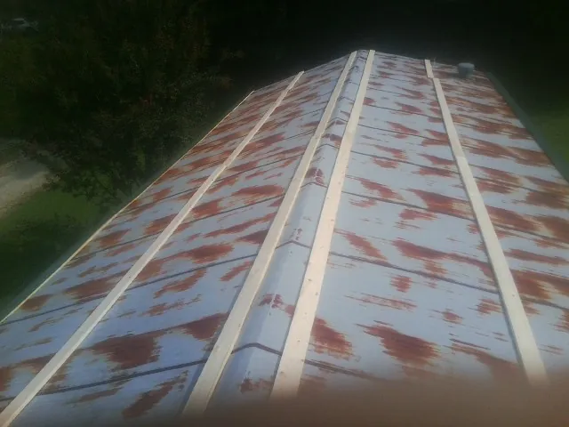 Rusted metal roof panels with new wood purlins before replacement — Storm Damage Roof Repair in Irvington by Roofing Brothers