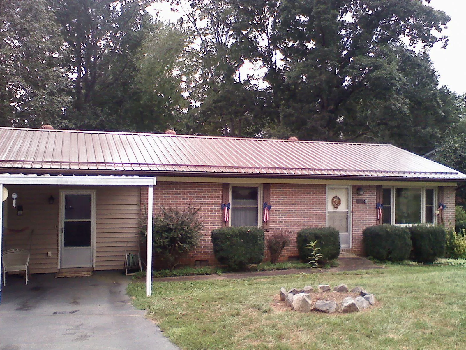 Bronze metal roof and carport on a brick ranch home — Roof Repair work by our crew in Irvington